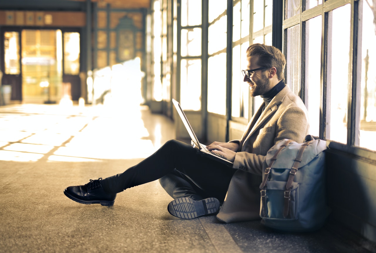 a person sitting on a bench using a laptop