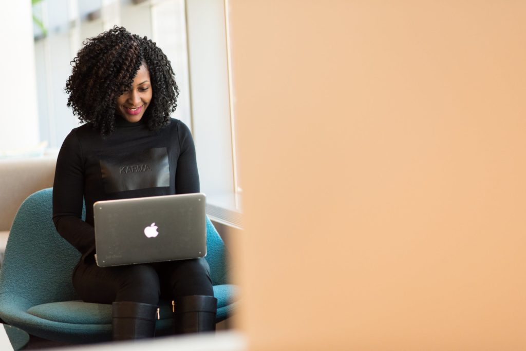 a person sitting on a couch using a laptop