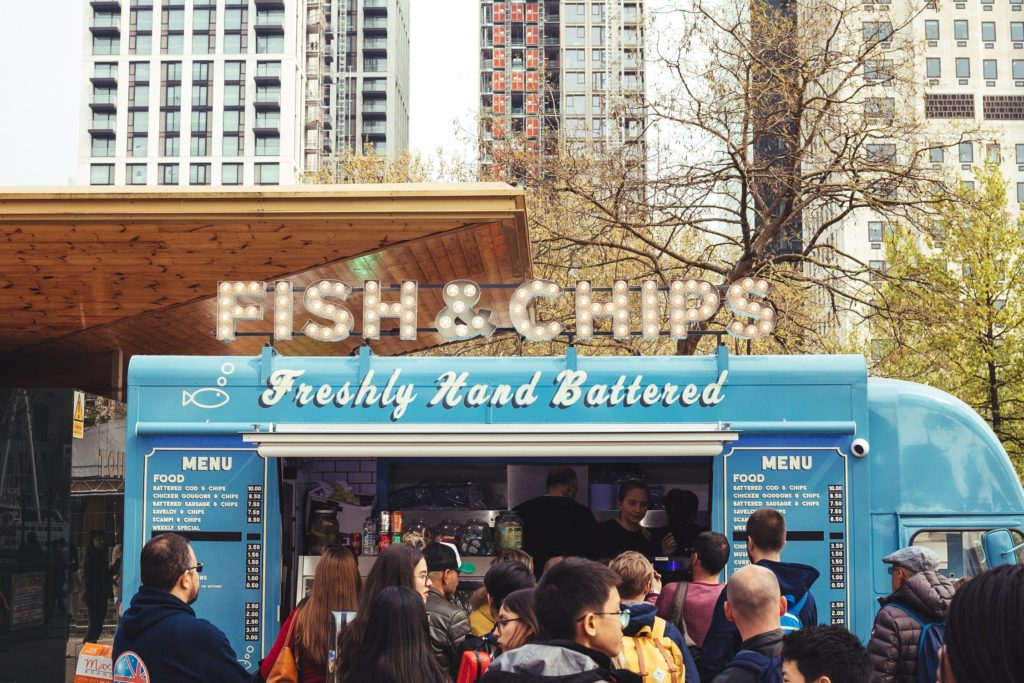 a group of people standing outside a food truck