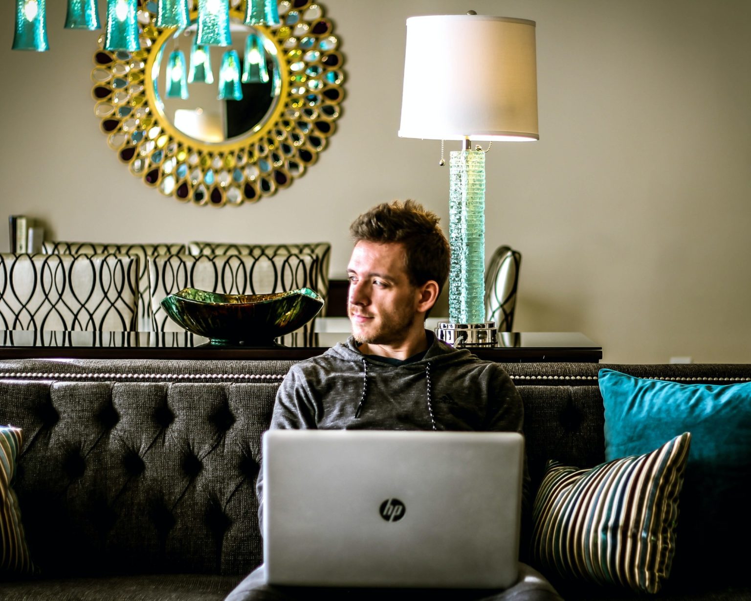 a person sitting on a couch with a laptop