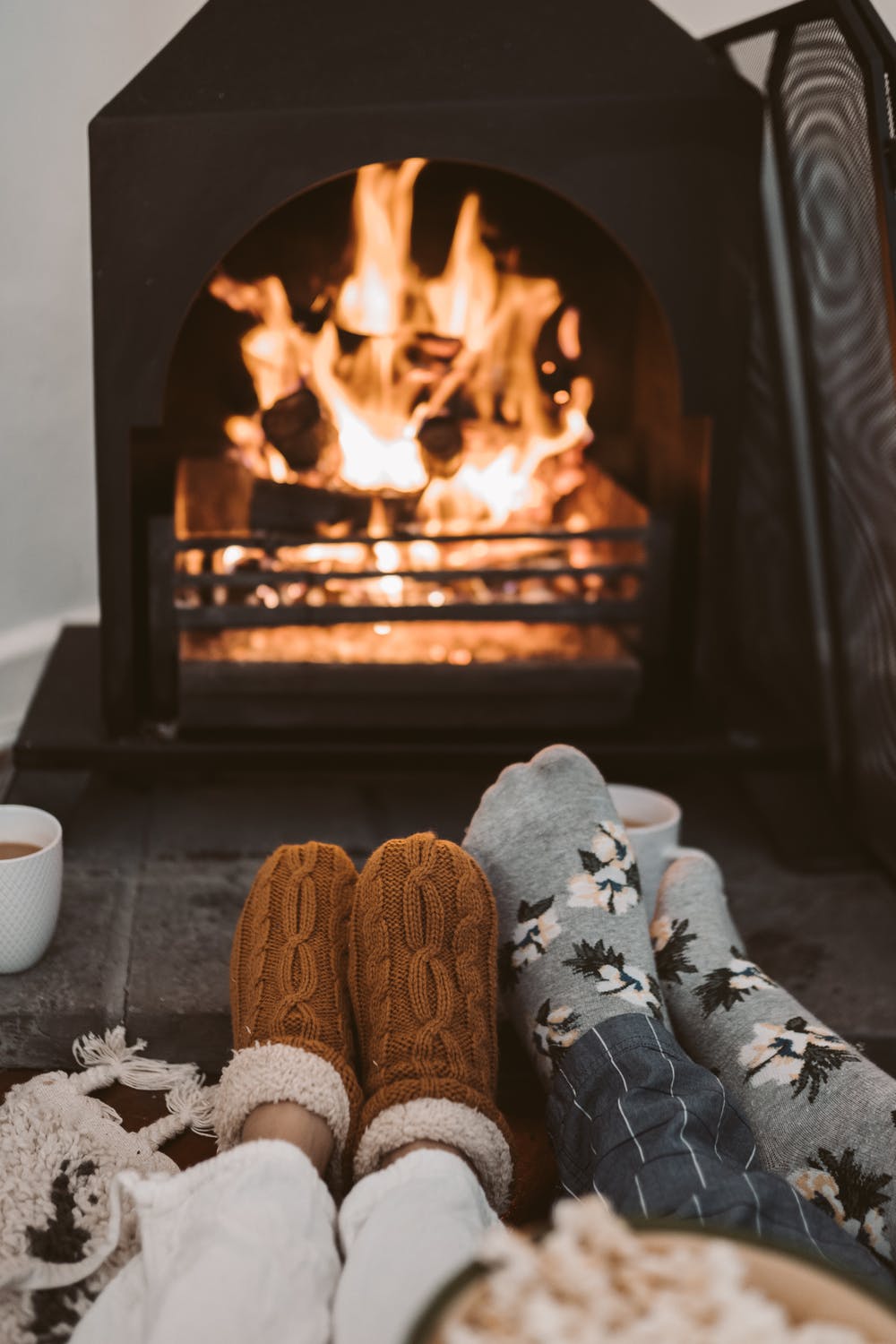a person's feet in front of a fireplace