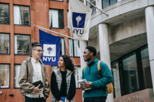 a group of people standing outside a building with flags