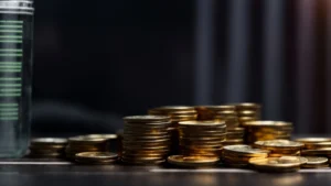 a stack of coins on a table with a graph in the background, illustrating financial growth.